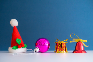Christmas Concept with copy space.Small Santa Claus hat with ornament balls,bell,pineconse and small present.