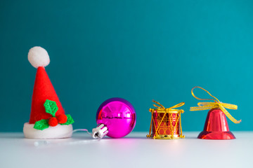 Christmas Concept with copy space.Small Santa Claus hat with ornament balls,bell,pineconse and small present.