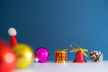 Christmas Concept with copy space.Small Santa Claus hat with ornament balls,bell,pineconse and small present.