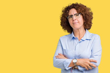 Beautiful middle ager senior businees woman wearing glasses over isolated background skeptic and...