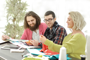 designers discussing new fabric patterns in the Studio.