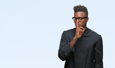 Young african american priest man over isolated background asking to be quiet with finger on lips. Silence and secret concept.