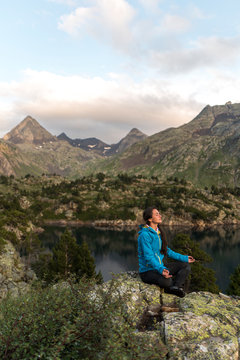 Female hiker meditating in an alpine scenery
