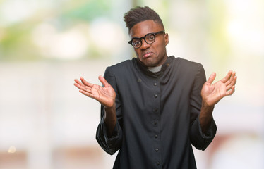 Young african american priest man over isolated background clueless and confused expression with...