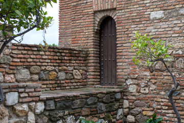 Ancient iron-upholstered wooden door in the wall of the house of the medieval city