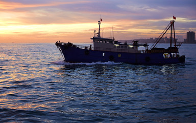 Fishing ship at sea, in sunset time