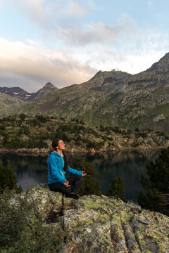 Female hiker meditating in an alpine scenery