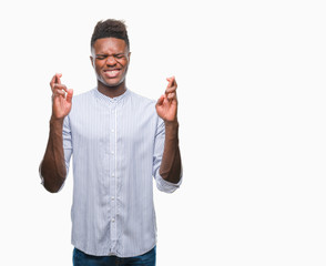 Young african american man over isolated background smiling crossing fingers with hope and eyes closed. Luck and superstitious concept.