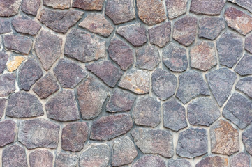 Fragment of masonry. The wall is made of natural stone. Background.