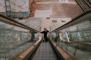 man listening to music and dancing while go up on mechanical stairs