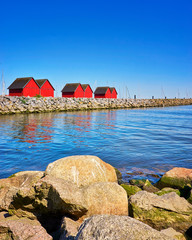 View over the stone groyne to the fishermen's houses at the harbor Weiße Wiek in Boltenhagen at...