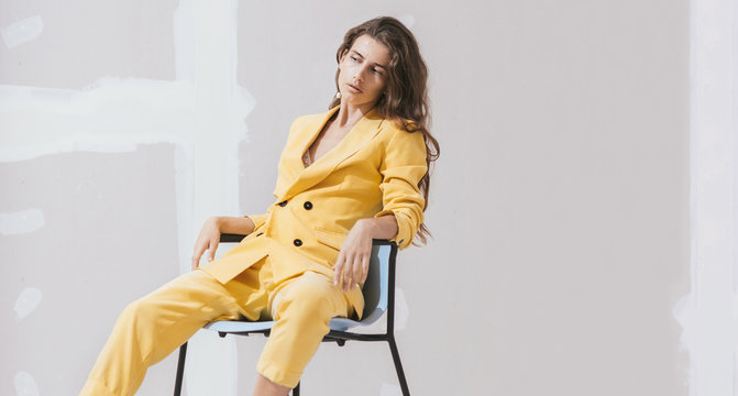 Young female /fashion model in abstract white space with yellow outfit.