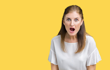 Middle age mature beautiful woman over isolated background afraid and shocked with surprise expression, fear and excited face.