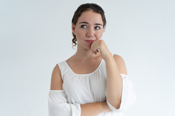 Fototapeta premium Dreamy lovely woman touching chin. Young lady looking away. Contemplation concept. Isolated front view on white background.