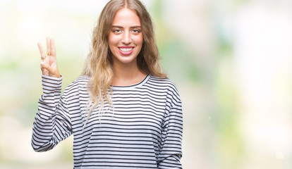 Beautiful young blonde woman wearing stripes sweater over isolated background showing and pointing up with fingers number three while smiling confident and happy.