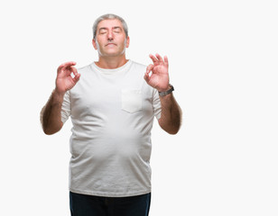 Handsome senior man over isolated background relax and smiling with eyes closed doing meditation gesture with fingers. Yoga concept.