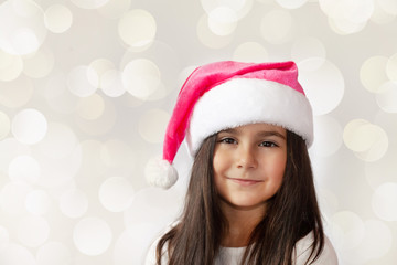 Christmas time - happy cheerful child girl in Santa Claus Hat 