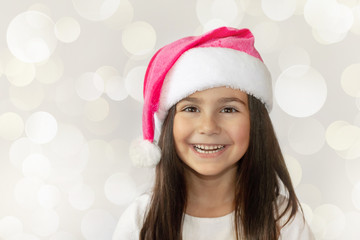Christmas time - happy cheerful child girl in Santa Claus Hat 