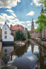 Fototapeta premium Impression of the Dutch city of Amersfoort with the Onze Lieve Vrouwetoren in the background and floating modern art in the canal