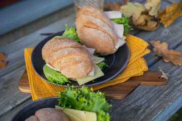 Ciabatta baguette sandwiches with ham, cheese, lettuce and a glass of beer