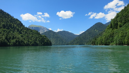 a lake among the mountains under blue sky with clouds