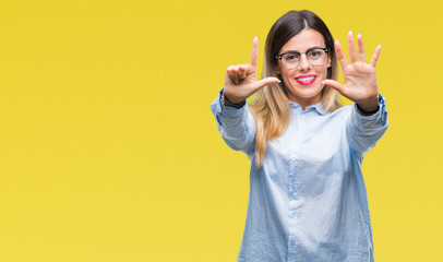 Young beautiful business woman wearing glasses over isolated background showing and pointing up with fingers number seven while smiling confident and happy.
