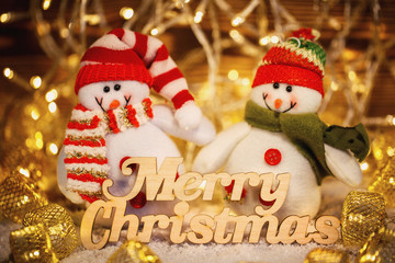 Toys on shiny garlands background. Merry Christmas and happy New Year. Wooden text.