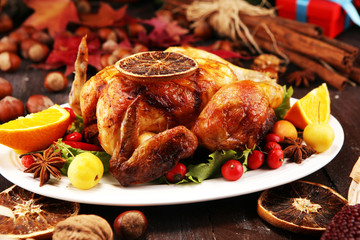 Baked turkey or chicken. The Christmas table is served with a turkey, decorated with fruits, salad and nuts. Fried chicken, table. Christmas dinner