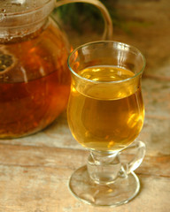 green tea in a transparent teapot on the table (herbal tea is brewed). top view.