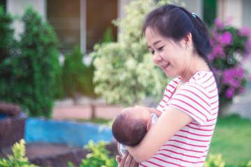 Asian Mother holding baby with love.