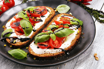 Bread with cream cheese and tomato for lunch table. Sharing antipasti on party or summer picnic time over wooden rustic background