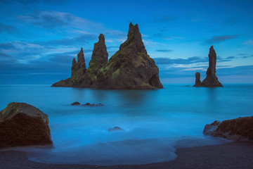 The Reynisdrangur - known rock needles in the Atlantic Ocean in southern Iceland after sunset
