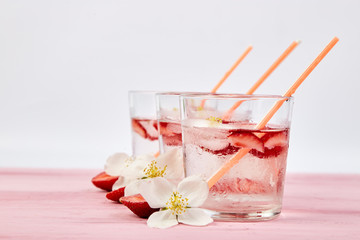 Strawberry detox water with jasmine flower. Summer iced drink or tea.