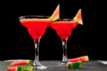 Watermelon margarita cocktail on black background. Fresh watermelon lemonade