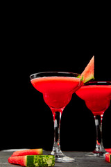Watermelon margarita cocktail on black background. Fresh watermelon lemonade