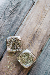 Dried spices in glass jars on wooden table