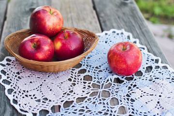 Red apples on a wooden table in autumn