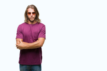 Fototapeta premium Young handsome man with long hair wearing sunglasses over isolated background skeptic and nervous, disapproving expression on face with crossed arms. Negative person.