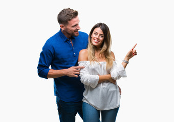 Young couple in love over isolated background with a big smile on face, pointing with hand and finger to the side looking at the camera.