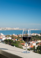 Glass of red wine from a balcony with a view during the day