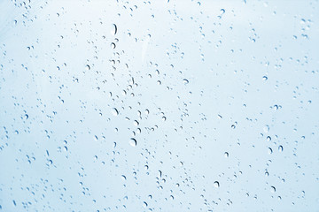 Blured water drops on window in navy blue tone.