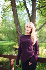 A walk in the Park. A girl with blond hair walks in the Park on a Sunny spring day. Blonde in the sun