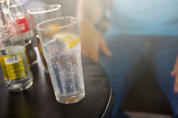 Full glass of soda water and half slice of lemon on the desk