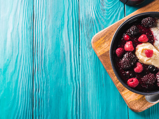 Vegan cashew milk Chia pudding with berries and home made almond butter served in a bowl on wooden board