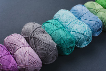 Colorful skeins of yarn on a gray-blue background. Studio shooting.