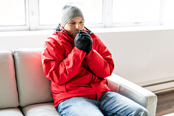 A Man With Warm Clothing Feeling The Cold Inside House on the sofa
