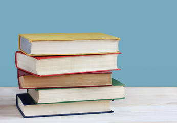 Pile of books in color covers on the table. Empty space for text.