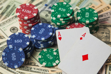 Poker chips on dollars and two aces