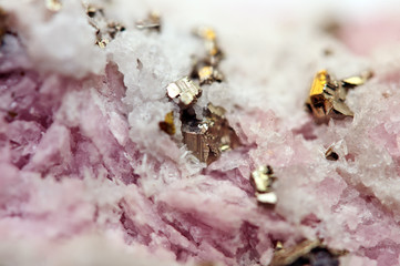 Pink crystals Rhodochrosite with particles of Pyrite. Natural  texture of mineral for background. Beautiful background and wallpaper. Macro.