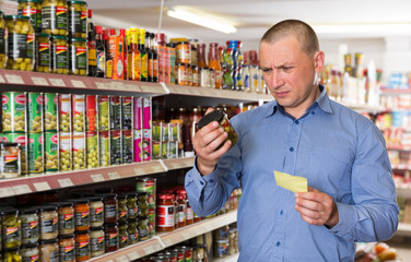 man purchasing food products on shopping list